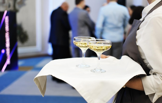 Taca z dwoma kieliszkami szampana Kelner podaje szampana gościom imprezy