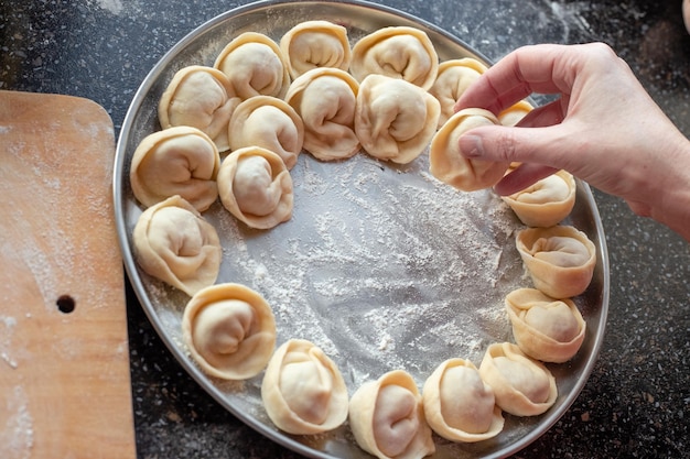 Taca z knedlami przygotowanymi do gotowania Gotowanie domowych pierogów