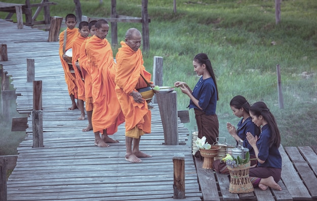 Zdjęcie tajska kobieta w tradycyjnych strojach okazujących szacunek mnichom