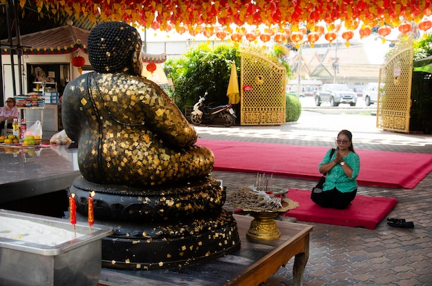 Zdjęcie tajska staruszka odwiedza i szanuje modląc się katyayana lub gautama budda tajskim wezwaniem phra sangkatjay w wat chong lom 31 stycznia 2017 r. w samut sakhon w tajlandii