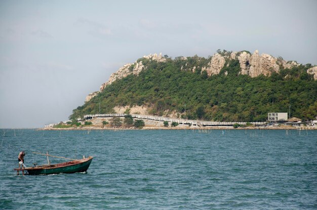 Tajski mężczyzna jedzie na drewnianą łódź rybacką jedzie na wybrzeże Laem thaen Scenic Lookout Plaża Bangsaen i morze w Chon Buri Tajlandia