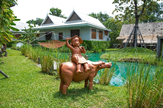 Tajski posąg dzieci jeżdżących na bawołach