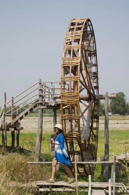 Tajskie Kobiety Podróżują I Pozują Z Dużym Drewnianym Kołem Wodnym Do Belowania Turbiny Lub Drewnianą Wodą Noria Z Krajobrazem Góry Pola Ryżowego W Thai Dam Cultural Village W Chiang Khan W Loei Tajlandia