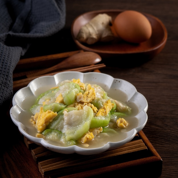 Tajwańska jajecznica domowej roboty z tykwą i olejem sezamowym na talerzu na rustykalnym stole