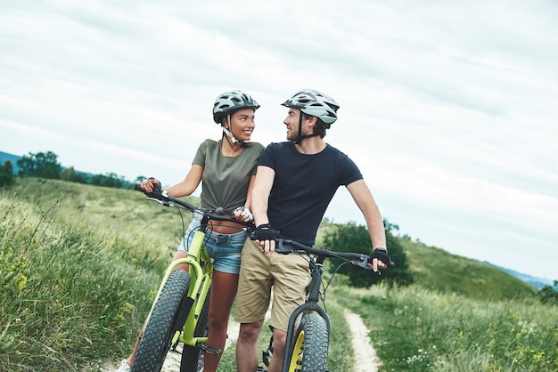 Tak blisko siebie mężczyzna w ochronie i fatbike wpatruje się w swoją dziewczynę