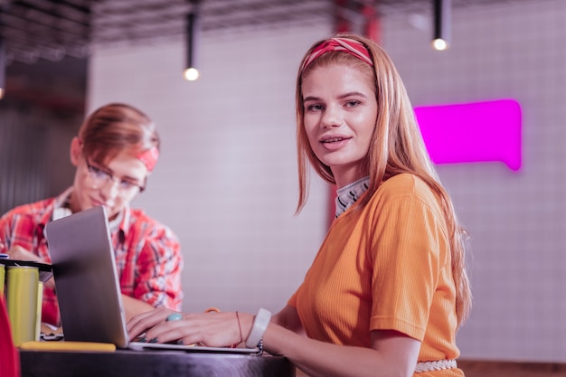 Taki słodki. Niesamowity długowłosy nastolatek za pomocą laptopa