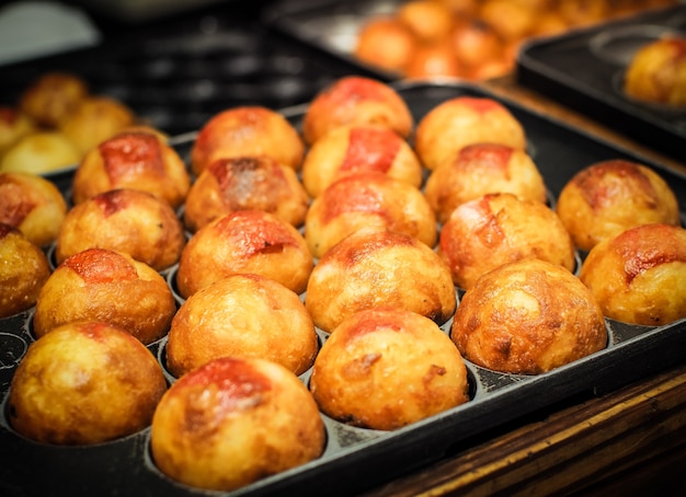 Zdjęcie takoyaki gotują na gorącej patelni. japoński słynny street food.