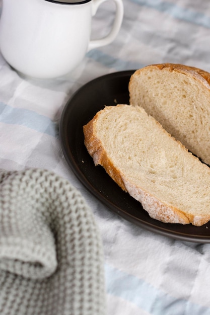 Talerz chleba na stole z filiżanką kawy.