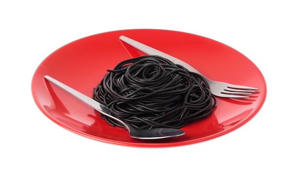 Talerz czarny makaron spaghetti na białym tle.