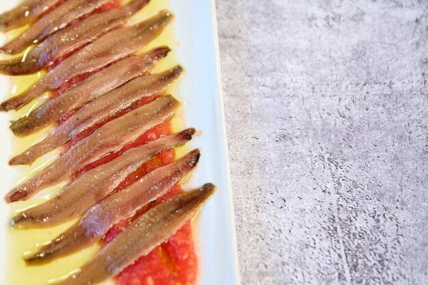 Talerz kantabryjskich anchois z oliwą z oliwek z pierwszego tłoczenia i pomidorami