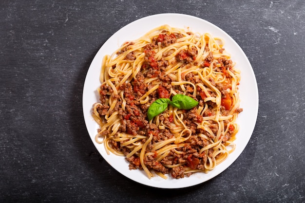 Talerz makaronu bolognese na ciemny, widok z góry