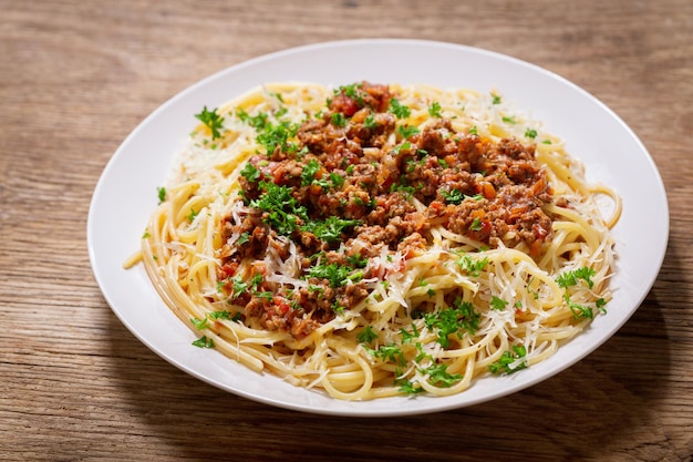 Talerz makaronu Bolognese na drewnianym tle