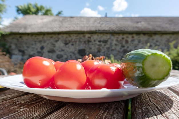 talerz pomidorów i ogórków na stole.