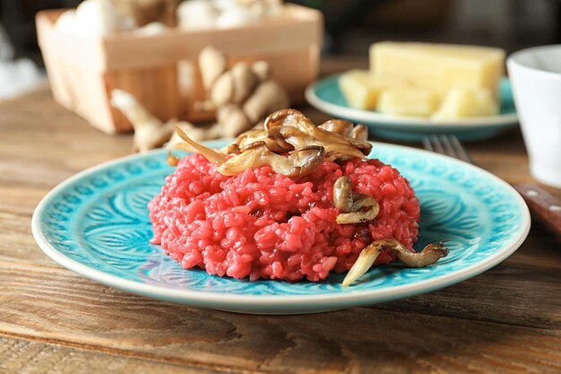 Talerz smacznego risotto z buraków z grzybami na stole zbliżenie