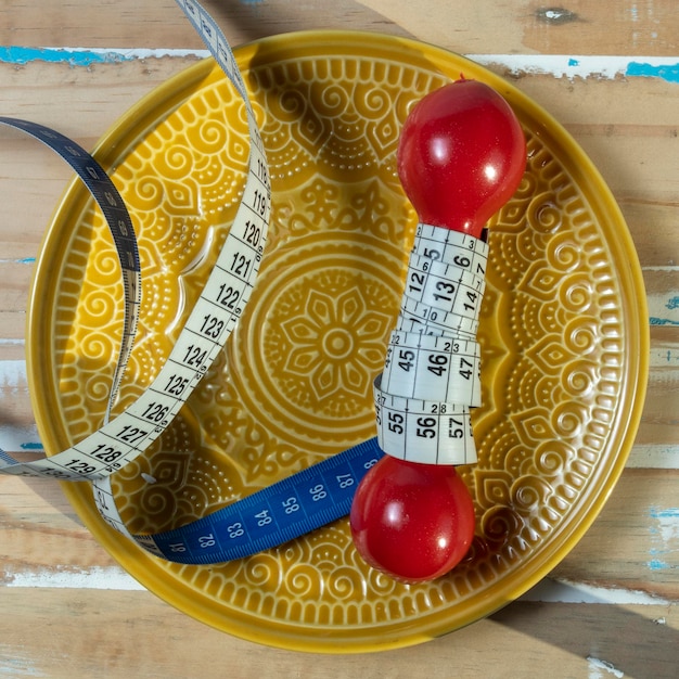 Zdjęcie talerz z jedzeniem z ciężarem ćwiczeniowym wewnątrz symbolizującym aktywność fizyczną w walce z otyłością