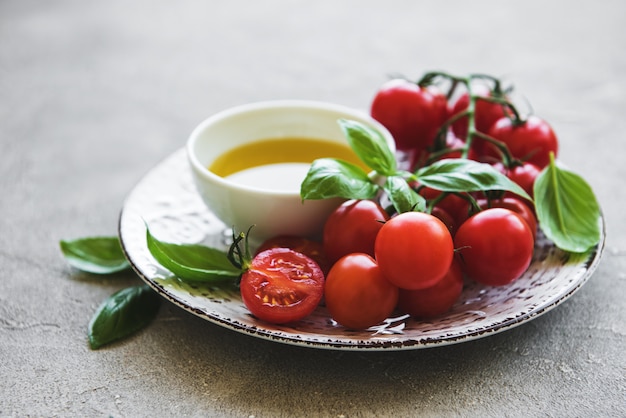 Talerz z pomidorami cherry, oliwą z oliwek i bazylią