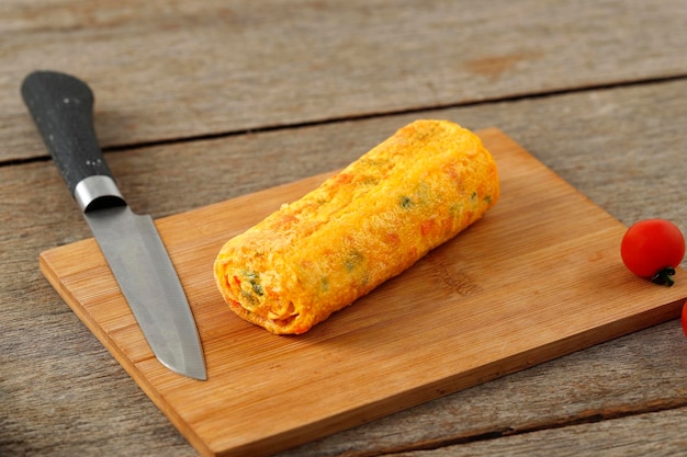 Tamagoyaki na drewnianej desce do krojenia i japoński omlet z jajkiem