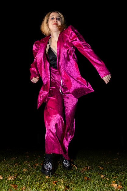 Tancerka w metalicznym różowym stroju w nocy