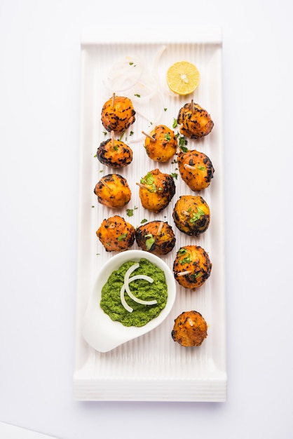 Tandoori aloo to pieczone ziemniaki z indyjskimi przyprawami. To imprezowa przystawka podana z zielonym chutney. selektywne skupienie