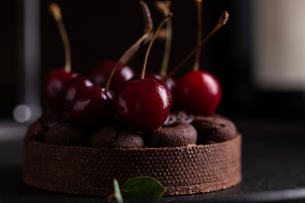 Tarta czekoladowa z ganache ozdobiona świeżą wiśnią