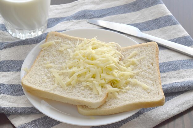 Tarty ser na krojonym chlebie na białym talerzu