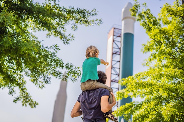 Tata i syn patrzą na rakietę Dziecko bawiące się z ojcem latem Szczęśliwy tata i syn na zewnątrz Koncepcja lidera sukcesu i zwycięzcy