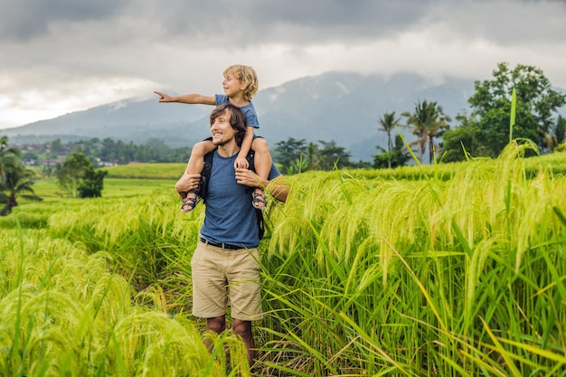 Tata i syn podróżujący na pięknych tarasach ryżowych Jatiluwih na tle słynnych wulkanów na Bali, Indonezja Podróżowanie z koncepcją dzieci