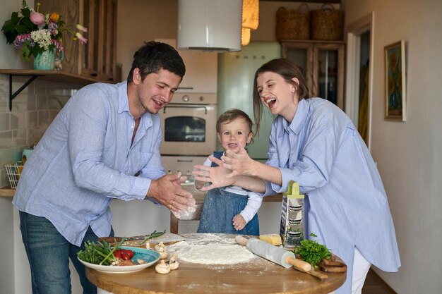 Tata mama i ich córka wspólnie gotują pizzę w kuchni Koncepcja szczęśliwej rodziny