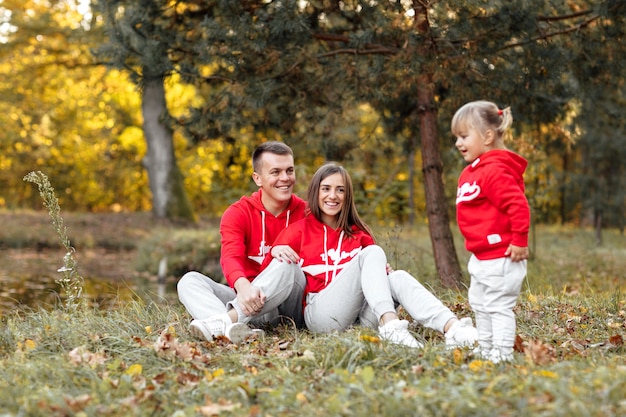 Tata, mama i mała śliczna córeczka bawią się i bawią w jesiennym parku.