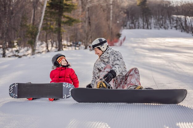 Tata uczy syna snowboardu Zajęcia dla dzieci w zimie Sporty zimowe dla dzieci Styl życia