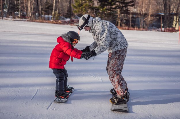 Tata uczy syna snowboardu Zajęcia dla dzieci w zimie Sporty zimowe dla dzieci Styl życia