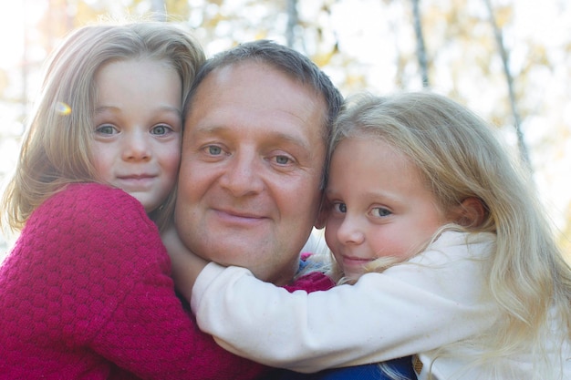 Tata z córkami przytula się z bliska