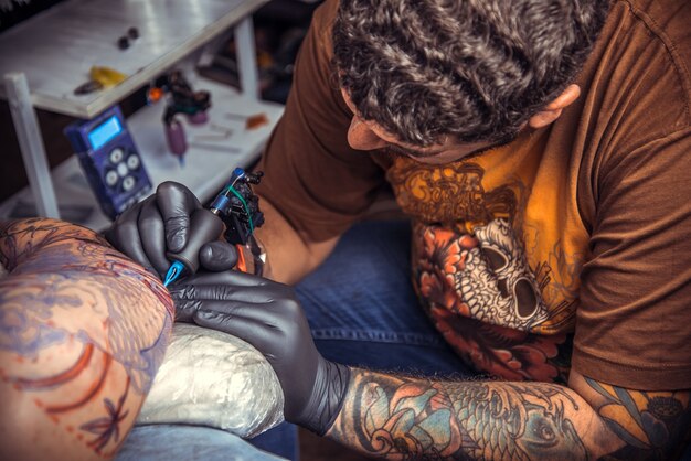 Tattooist wykonuje tatuaże w studio tatuażu