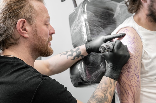 Tatuażysta wykonujący tatuaż w studio Wysokiej jakości fotografia