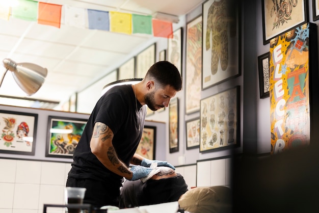 Zdjęcie tatuażysta z widokiem z boku w pracy
