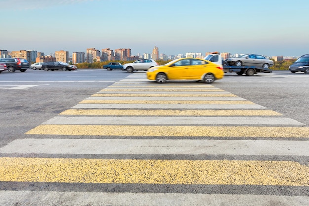 Taxi na żółtym i białym skrzyżowaniu zebra na ulicy