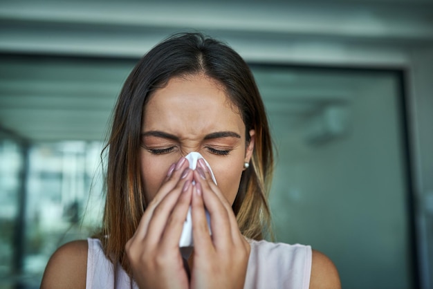 Te alergie to najgorsze ujęcie młodej bizneswoman, która wydmuchuje nos w biurze