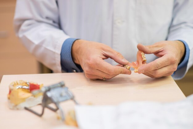 Technik dentystyczny wykonuje protezy częściowe Produkcja sztucznych zębów lub mostów dentystycznych Zbliżenie