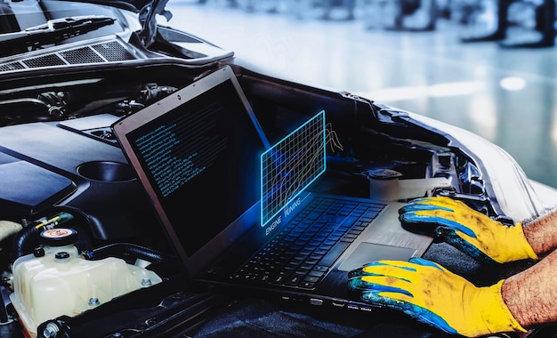 Technik dostraja samochód z silnikiem za pomocą oprogramowania komputerowego laptopa w warsztacie samochodowym wykres silnika świecący koncepcja usługi konserwacji motoryzacyjnej