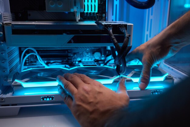 Technik komputerowy instaluje system chłodzenia komputera
