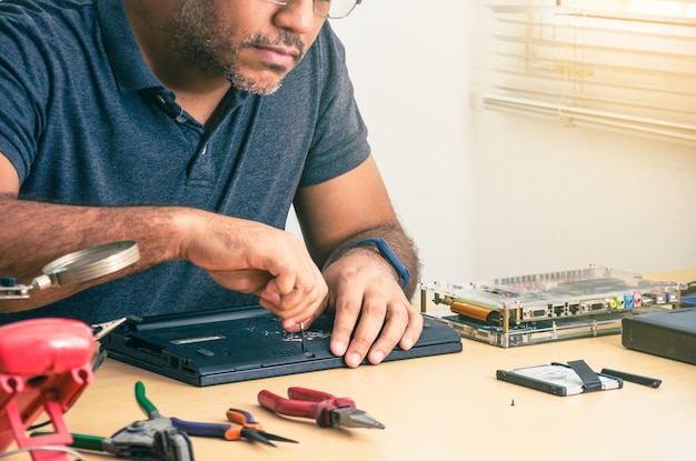 Technik Komputerowy Naprawiania Laptopa Na Biurku. Czarnoskóry. Narzędzia Pracy.