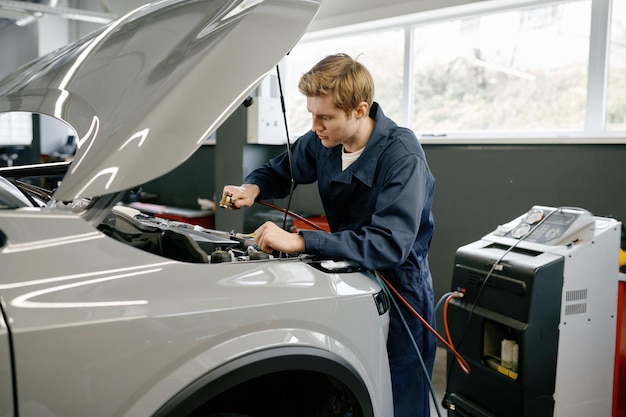 Zdjęcie technik męski wykonujący diagnostykę systemu klimatyzacji samochodowej