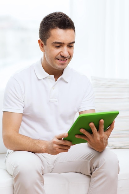 technologia, ludzie i styl życia, koncepcja uczenia się na odległość - szczęśliwy człowiek pracujący z komputerem typu tablet pc w domu