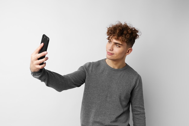 Technologia perwersyjnego faceta z telefonem selfie na białym tle