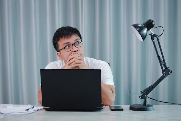 Technologia zdalna praca i koncepcja stylu życia szczęśliwy azjatycki mężczyzna w okularach.