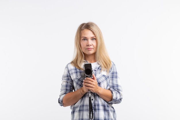 Technologie, fotografowanie i koncepcja ludzi - blondynka młoda kobieta z aparatem retro na białym