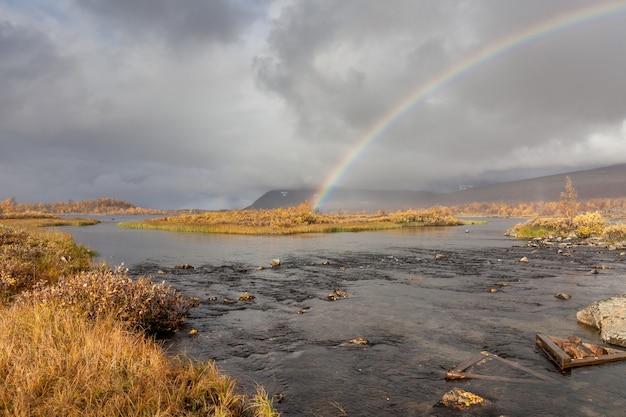 Tęcza nad rzeką w arktycznych górach Parku Narodowego Sarek.