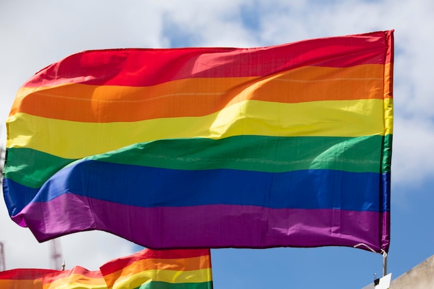 Tęczowa flaga dumy gejowskiej lgbt machana podczas uroczystości z okazji społeczności dumy