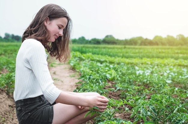 Teen Dziewczyna Dotyka Rąk Z Zielonymi Roślinami W Ogrodzie