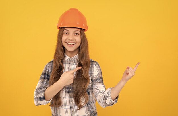Teen dziewczyna w kasku budowniczym dziecko w kraciastej koszuli budynku i koncepcji budowy